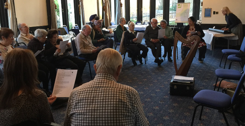 Helen Tierney playing the electric piano and harp for members at Dementia Club UK Helen Tierney playing the electric piano and harp for members at Dementia Club UK